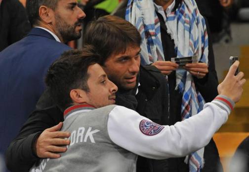 Intanto in tribuna il c.t. Antonio Conte osserva i 22 in campo e si lascia fotografare da un giovane tifoso. Ansa